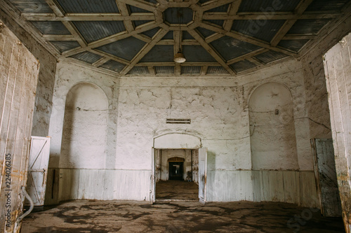 Round room in an old stable with open doors interior