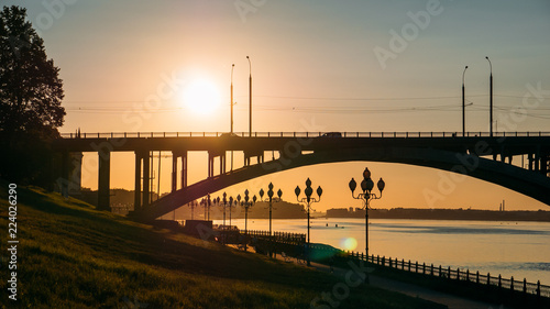 Panorama of sunset over river, modern bridge and city embankment, beautiful urban evening landscape © DedMityay