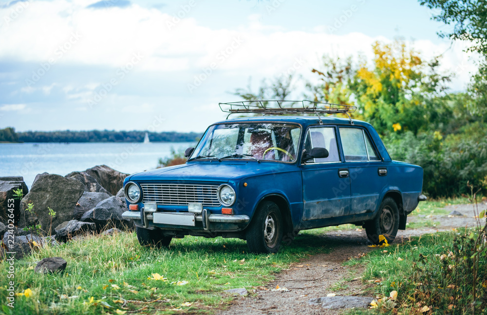 Autumn in England. Old car on the lake shore