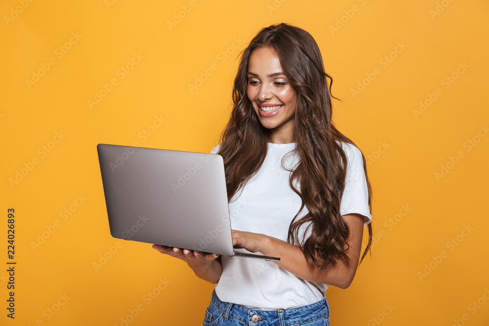 Φωτογραφία Portrait of happy woman 20s with long hair smiling and holding gray laptop, isol