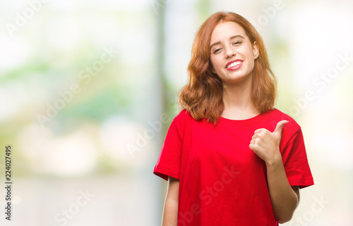 Fototapeta Naklejka Na Ścianę i Meble -  Young beautiful woman over isolated background doing happy thumbs up gesture with hand. Approving expression looking at the camera with showing success.