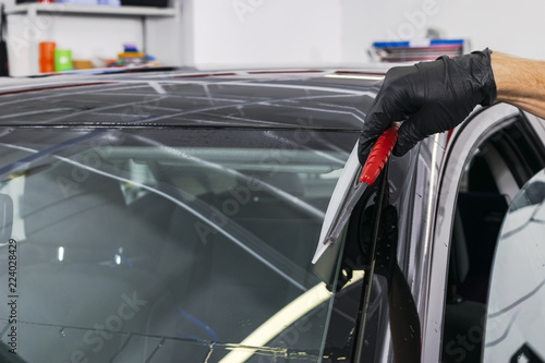 A man cleaning car with microfiber cloth, car detailing (or valeting) concept. Selective focus. Car detailing. Cleaning with sponge. Worker cleaning. Microfiber and cleaning solution to clean