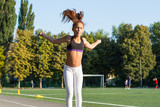 A teenage girl jumping rope in a school stadium.