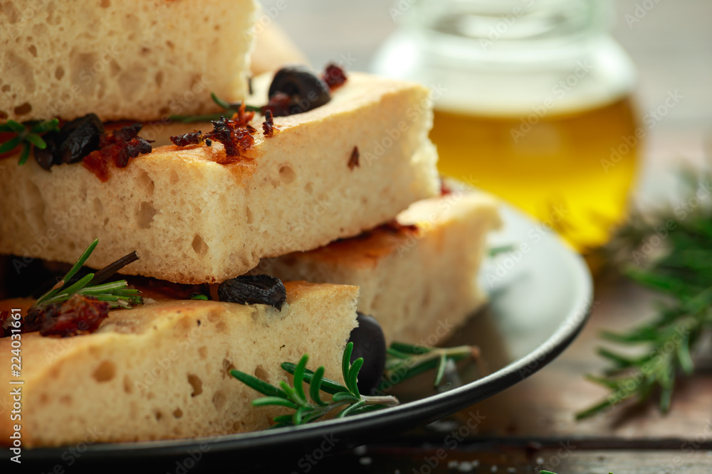 Homemade Italian focaccia with sun dried tomatoes, black olives and rosemary Homemade Italian focaccia with sun dried tomatoes, black olives and rosemary