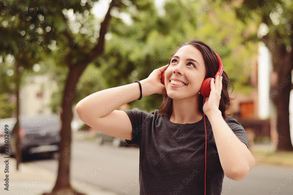 Portrait of young beautiful woman with red headphones listening music Portrait of young beautiful woman with red headphones listening music