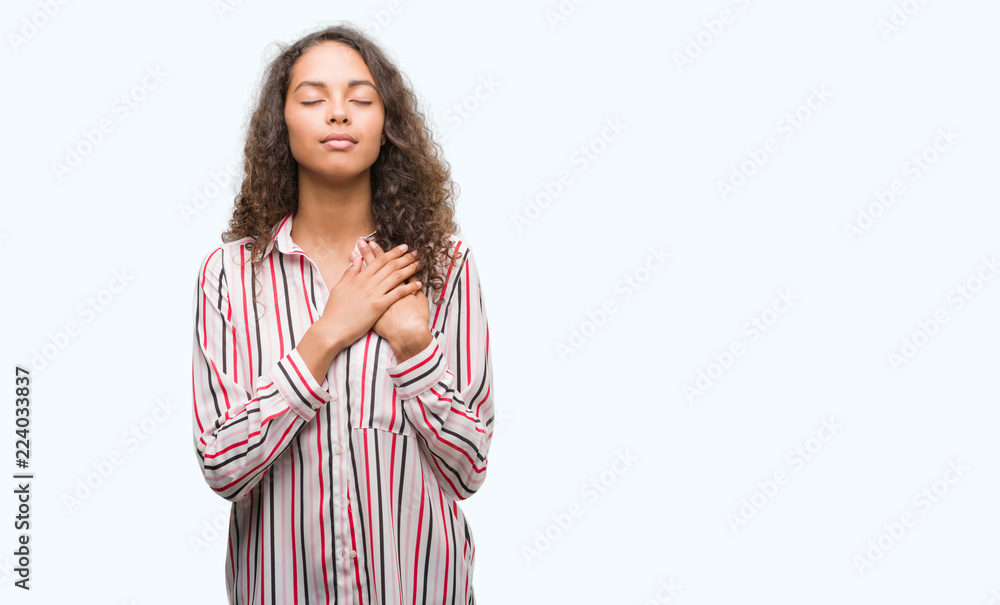 Beautiful young hispanic woman smiling with hands on chest with closed eyes and grateful gesture on face. Health concept. Beautiful young hispanic woman smiling with hands on chest with closed eyes and grateful gesture on face. Health concept.