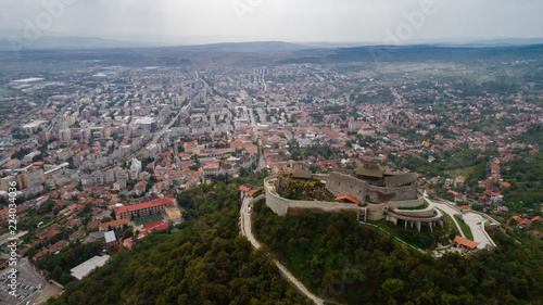 Aerial view of Deva Castle with the town in the background on a cloudy sky. © xpabli