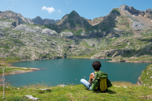 woman hiker resting and looking at lake in the Pyrenees mountains