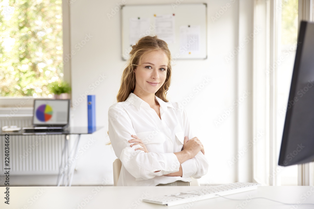 Beautiful young businesswoman sitting in the office Beautiful young businesswoman sitting in the office