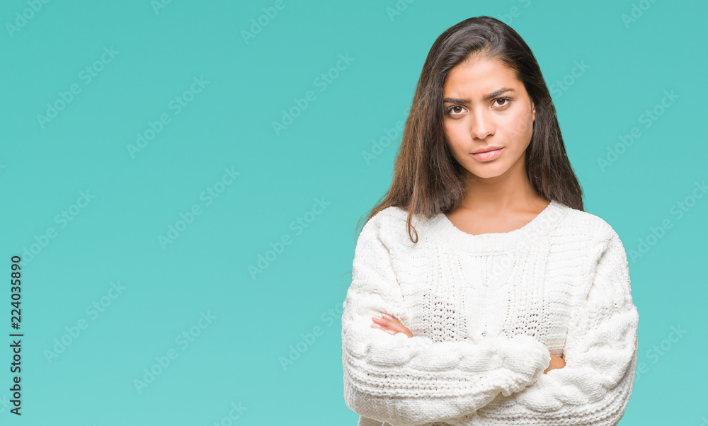 Obraz premium Young beautiful arab woman wearing winter sweater over isolated background skeptic and nervous, disapproving expression on face with crossed arms. Negative person.