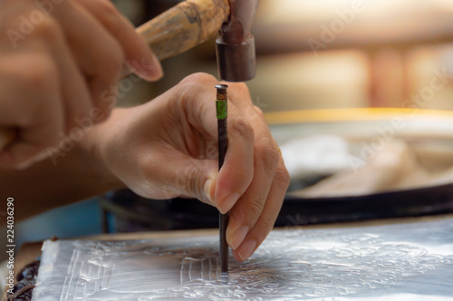 Vászonkép The artisans are using hammers and steel Engraved gorgeus pattern on silver plate To handcraft concept