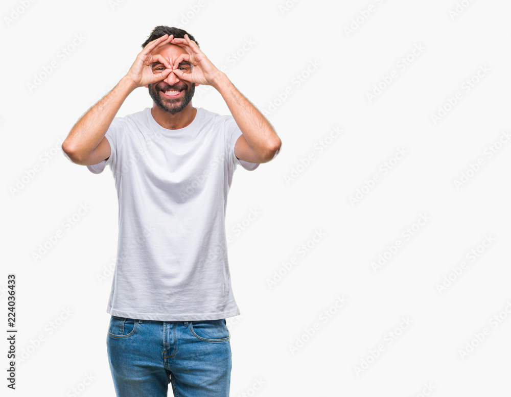 Adult hispanic man over isolated background doing ok gesture like binoculars sticking tongue out, eyes looking through fingers. Crazy expression. Adult hispanic man over isolated background doing ok gesture like binoculars sticking tongue out, eyes looking through fingers. Crazy expression.
