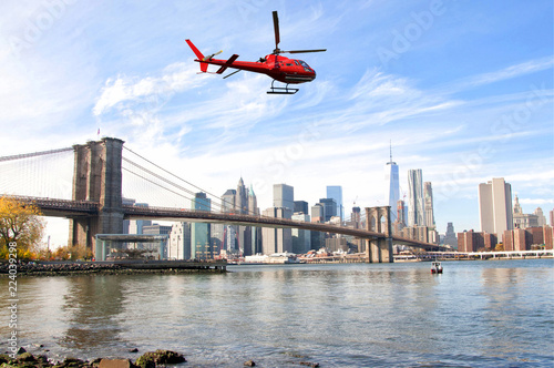 Helicopter flying over New York City skyscrapers and Brooklyn Bridge, USA