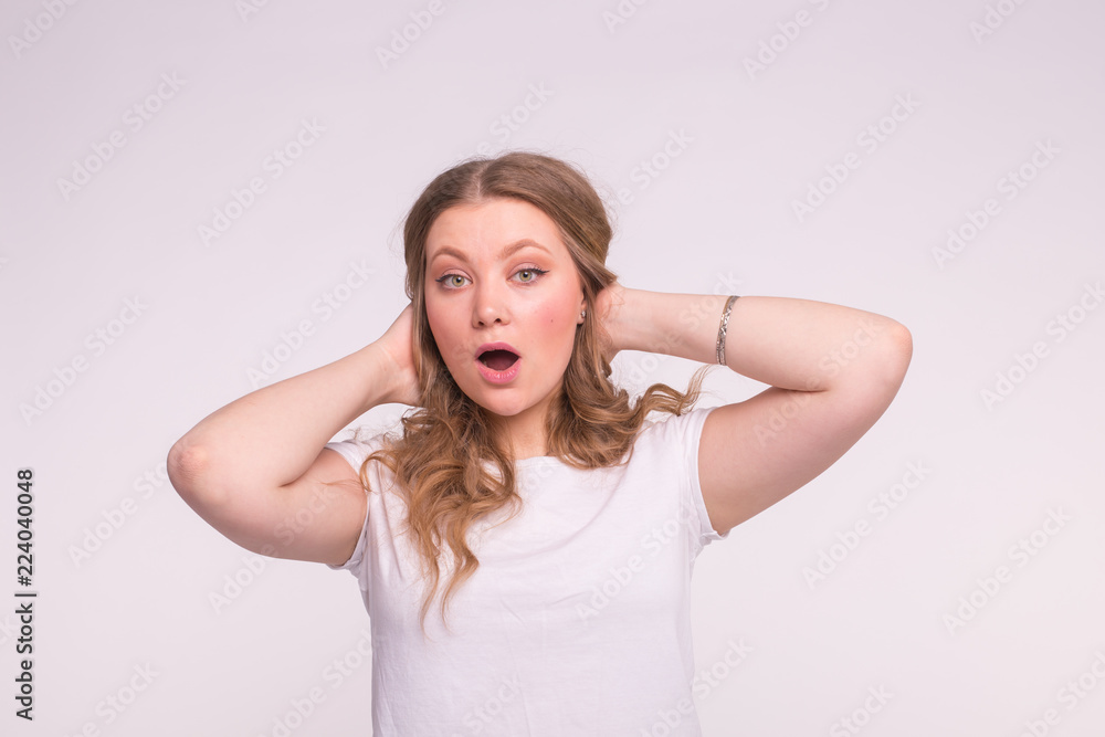 Portrait of surprised young woman with curly hair in white t-shirt. Portrait of surprised young woman with curly hair in white t-shirt.