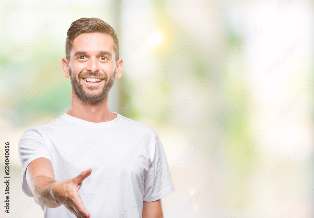 Young handsome man over isolated background smiling friendly offering handshake as greeting and welcoming. Successful business. Young handsome man over isolated background smiling friendly offering handshake as greeting and welcoming. Successful business.