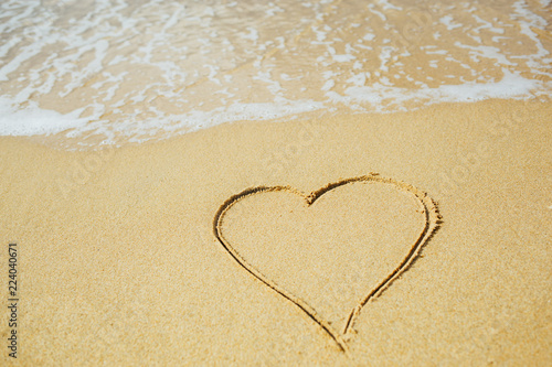 Heart shape draw on sandy beach. Love concept