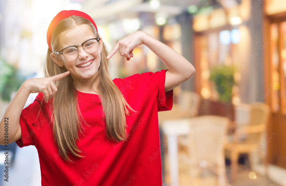 Young beautiful girl wearing glasses over isolated background smiling confident showing and pointing with fingers teeth and mouth. Health concept.