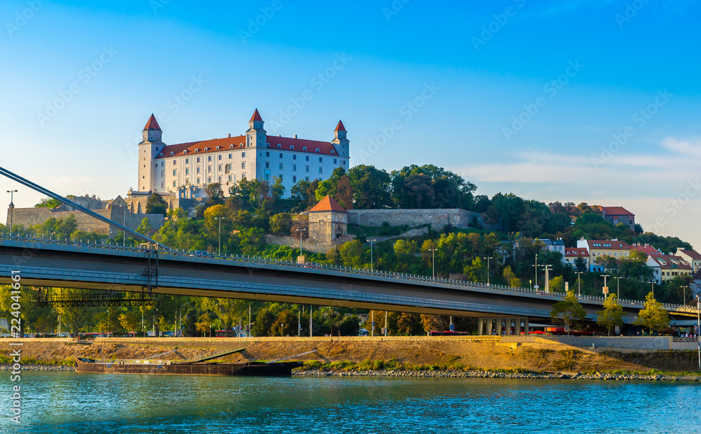 Bratislava castle over Danube river with new bridge in foreground.