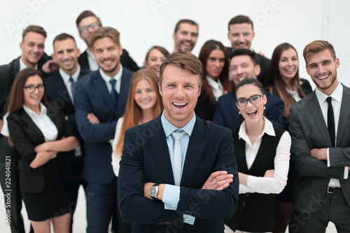 smiling businessman standing on background of her business team. © ASDF