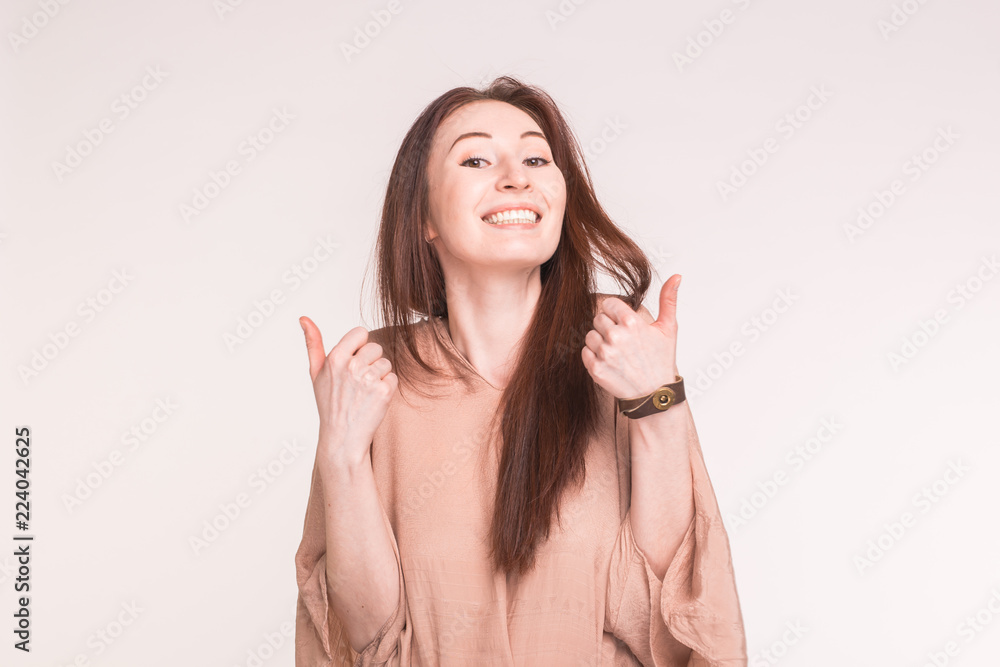 Fashion, style and gesture concept - smiling pretty asian woman over white background showing thumbs up Fashion, style and gesture concept - smiling pretty asian woman over white background showing thumbs up