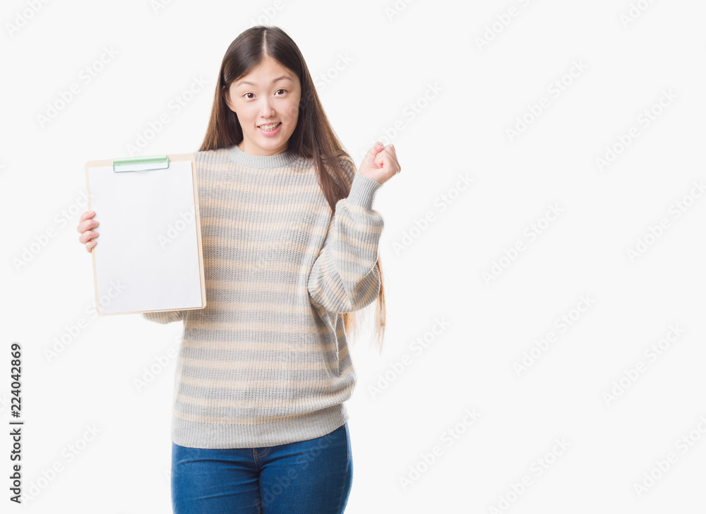 Young Chinese woman over isolated background holding clipboard screaming proud and celebrating victory and success very excited, cheering emotion Young Chinese woman over isolated background holding clipboard screaming proud and celebrating victory and success very excited, cheering emotion