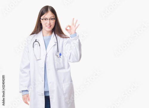Young Chinese doctor woman over isolated background smiling positive doing ok sign with hand and fingers. Successful expression.