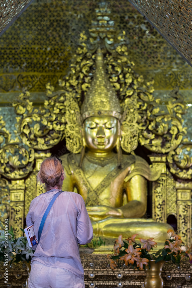 Tourist or Europion woman pay golden Buddha in Temple at Mandalay Hill, Myanmar. landmark and popular for tourist attractions Tourist or Europion woman pay golden Buddha in Temple at Mandalay Hill, Myanmar. landmark and popular for tourist attractions