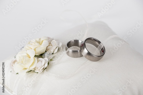  wedding rings - silver wedding rings on a white silk pillow