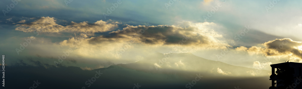 Naklejka premium Etna volcano with clouds surrounding the mountain top