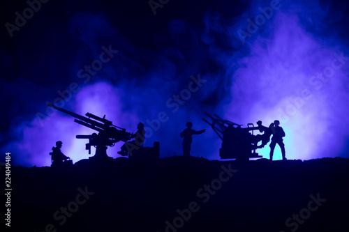 An anti-aircraft cannon and Military silhouettes fighting scene on war fog sky background  World War Soldiers Silhouettes Below Cloudy Skyline at sunset. Attack scene.