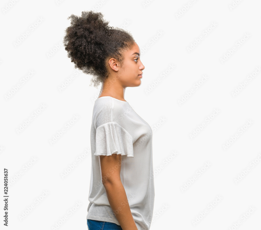 Young afro american woman over isolated background looking to side, relax profile pose with natural face with confident smile. Young afro american woman over isolated background looking to side, relax profile pose with natural face with confident smile.