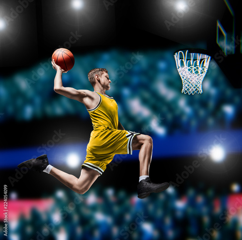 basketball player making slam dunk on basketball arena photo