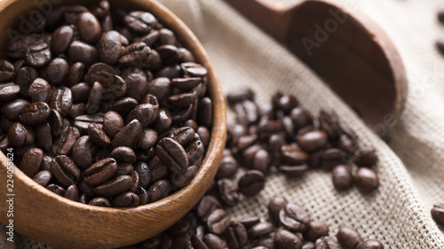 Roasted coffee beans in wooden bowl. Aromatic coffee beans