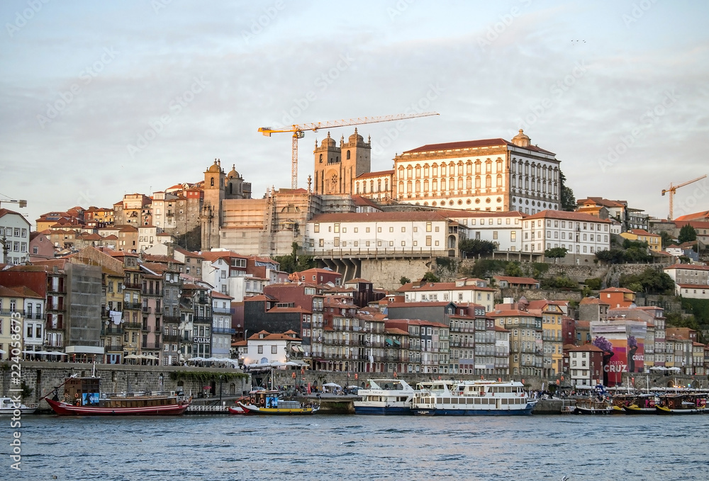Porto, old town with colorful houses and buildings, river and boats.