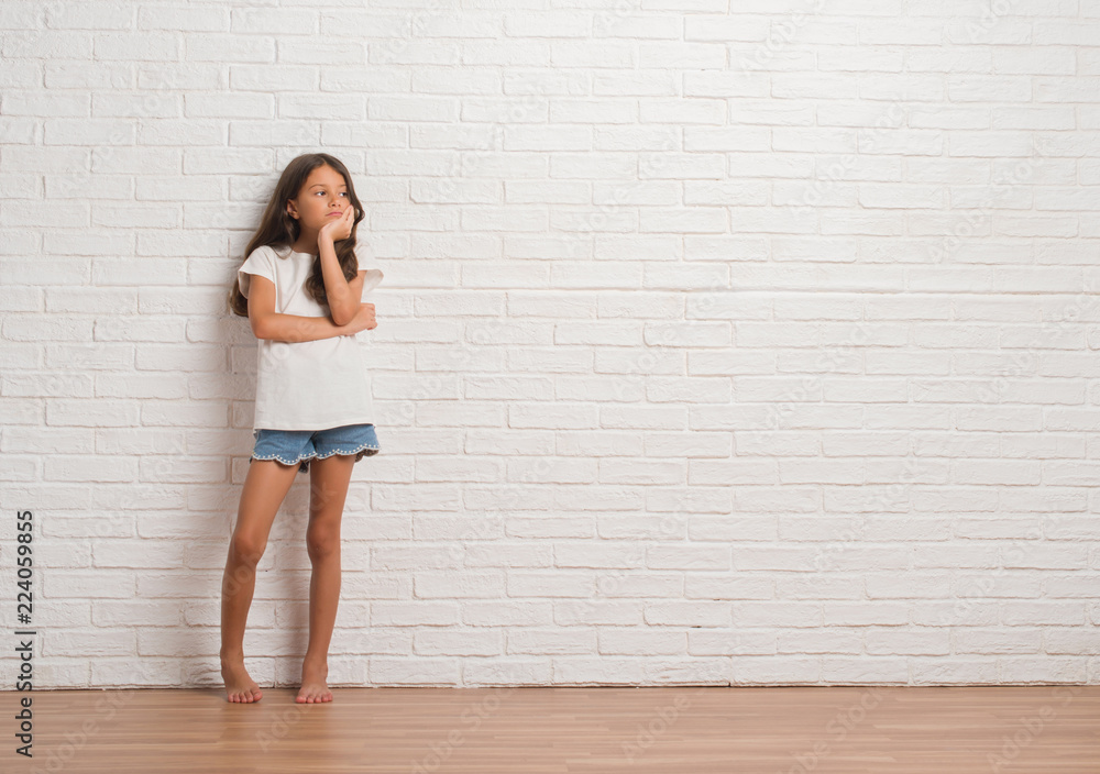 Young hispanic kid stading over white brick wall thinking looking tired and bored with depression problems with crossed arms. Young hispanic kid stading over white brick wall thinking looking tired and bored with depression problems with crossed arms.