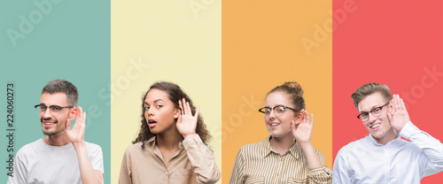Collage of a group of people isolated over colorful background smiling with hand over ear listening an hearing to rumor or gossip. Deafness concept.