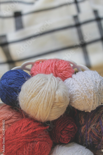 Knitting, comfort, needlework. Colored balls of yarn in a basket, knitting needles. Copyspace photo