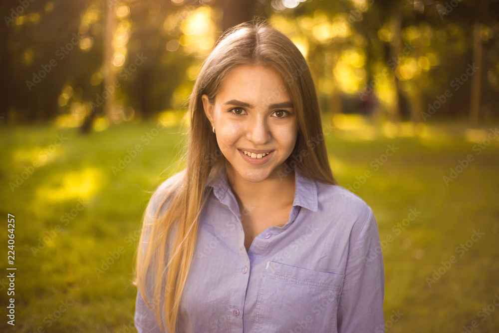 Happy laughing girl student sitting in the park outdoors on grass have a rest looking camera. Happy laughing girl student sitting in the park outdoors on grass have a rest looking camera.
