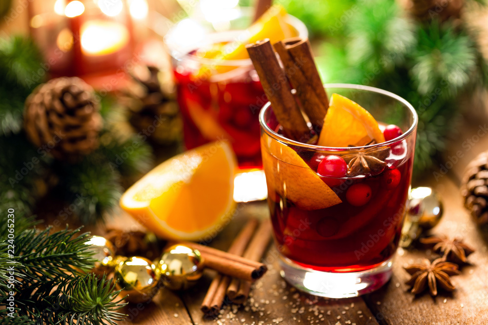 Christmas mulled red wine with spices and oranges on a wooden rustic table. Traditional hot drink at Christmas Christmas mulled red wine with spices and oranges on a wooden rustic table. Traditional hot drink at Christmas