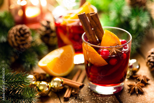 Christmas mulled red wine with spices and oranges on a wooden rustic table. Traditional hot drink at Christmas