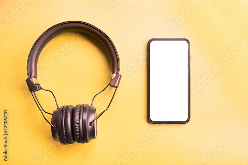 Headphones and smartphone on colorful background.