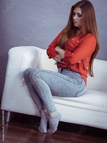 Angry woman sitting on sofa photo