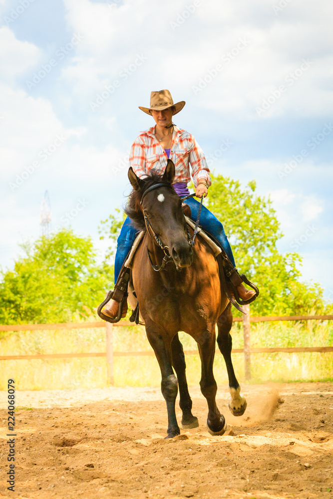 Cowgirl doing horse riding on countryside meadow Cowgirl doing horse riding on countryside meadow