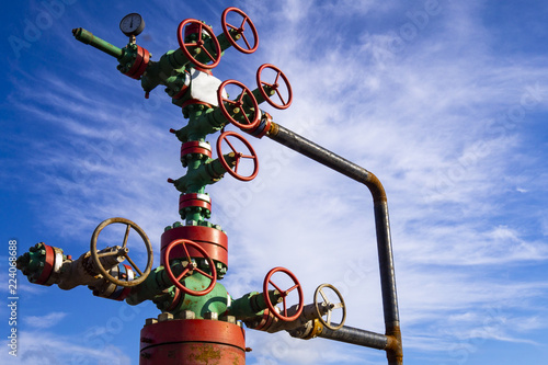 Horizontal view of a wellhead with valve armature. Oil and gas industry concept. Industrial site background. Toned.