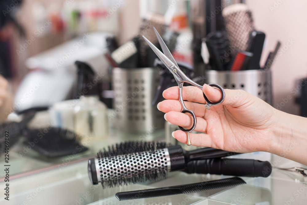 Hand of a hairdresser with scissors on the background of a hairdressing  workstation. Hairdresser working desk. Preparation for cutting hair. Beauty salon  working desk. Stock Photo | Adobe Stock