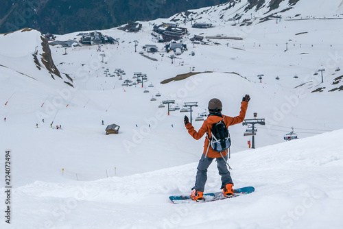 Happy snowboarder dancing and waving on the slope, enjoying great great holidays