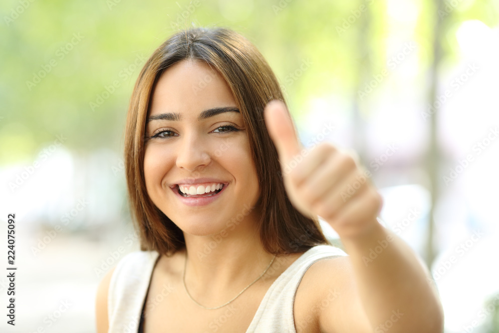 Happy teen looking at you in the street with thumb up Happy teen looking at you in the street with thumb up