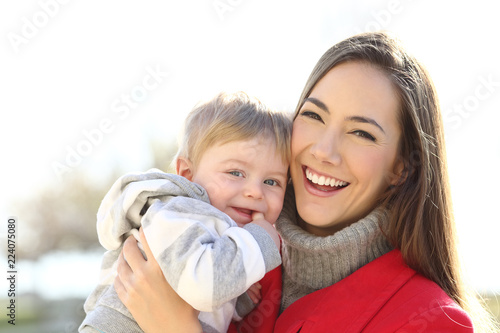 Happy mother holding her son baby looking at you