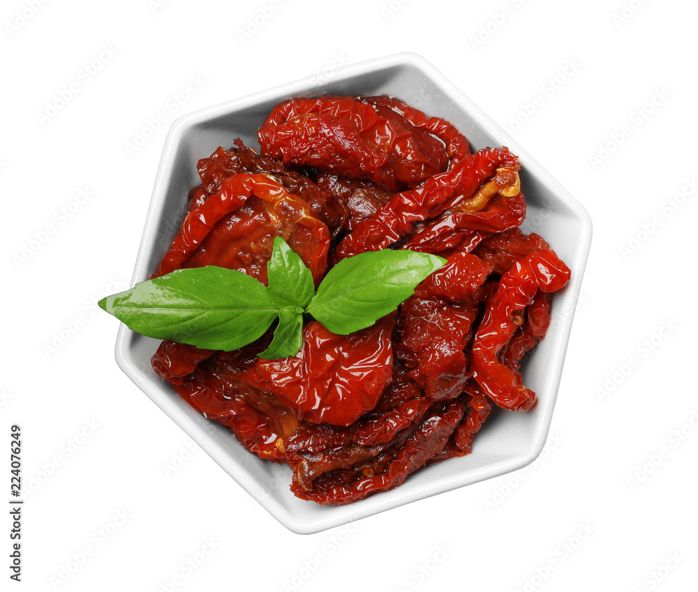 Bowl with sun dried tomatoes and green leaves on white background, top view Bowl with sun dried tomatoes and green leaves on white background, top view