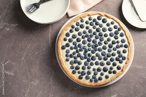 Flat lay composition with tasty blueberry cake and space for text on gray table